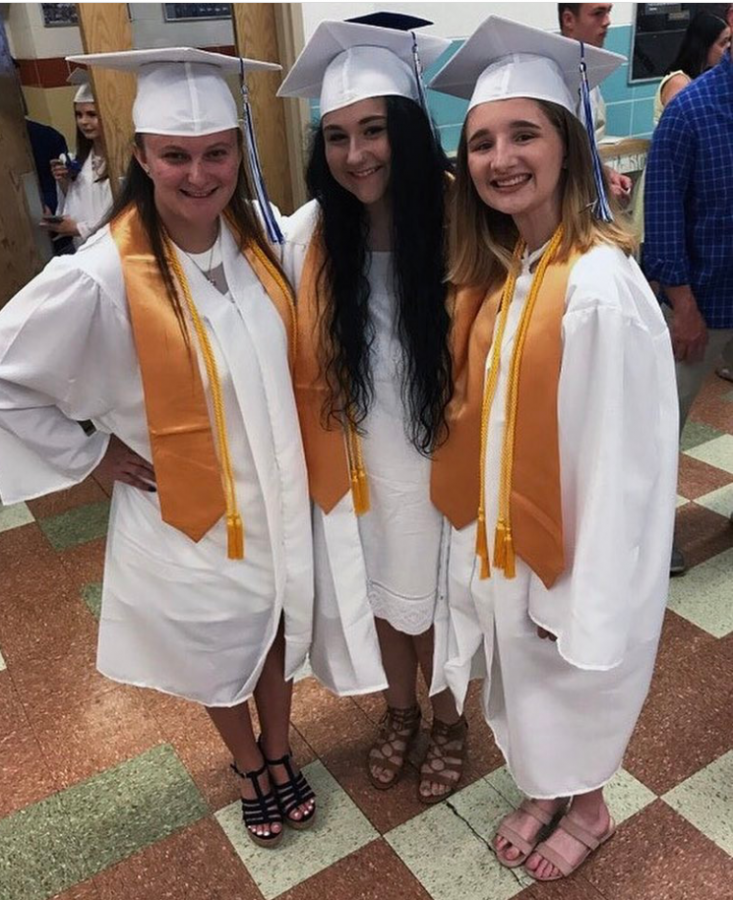 Three graduates posing in the cafeteria for the last time! 